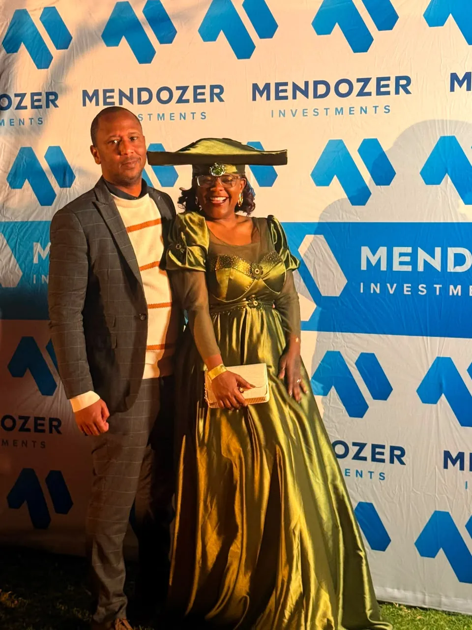 Attendees in front of a Mendozer-branded community event backdrop