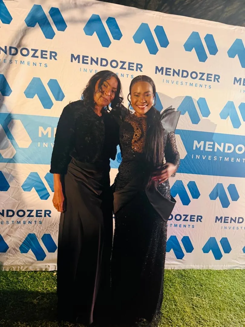 Guests in formal wear at a Mendozer-branded event backdrop