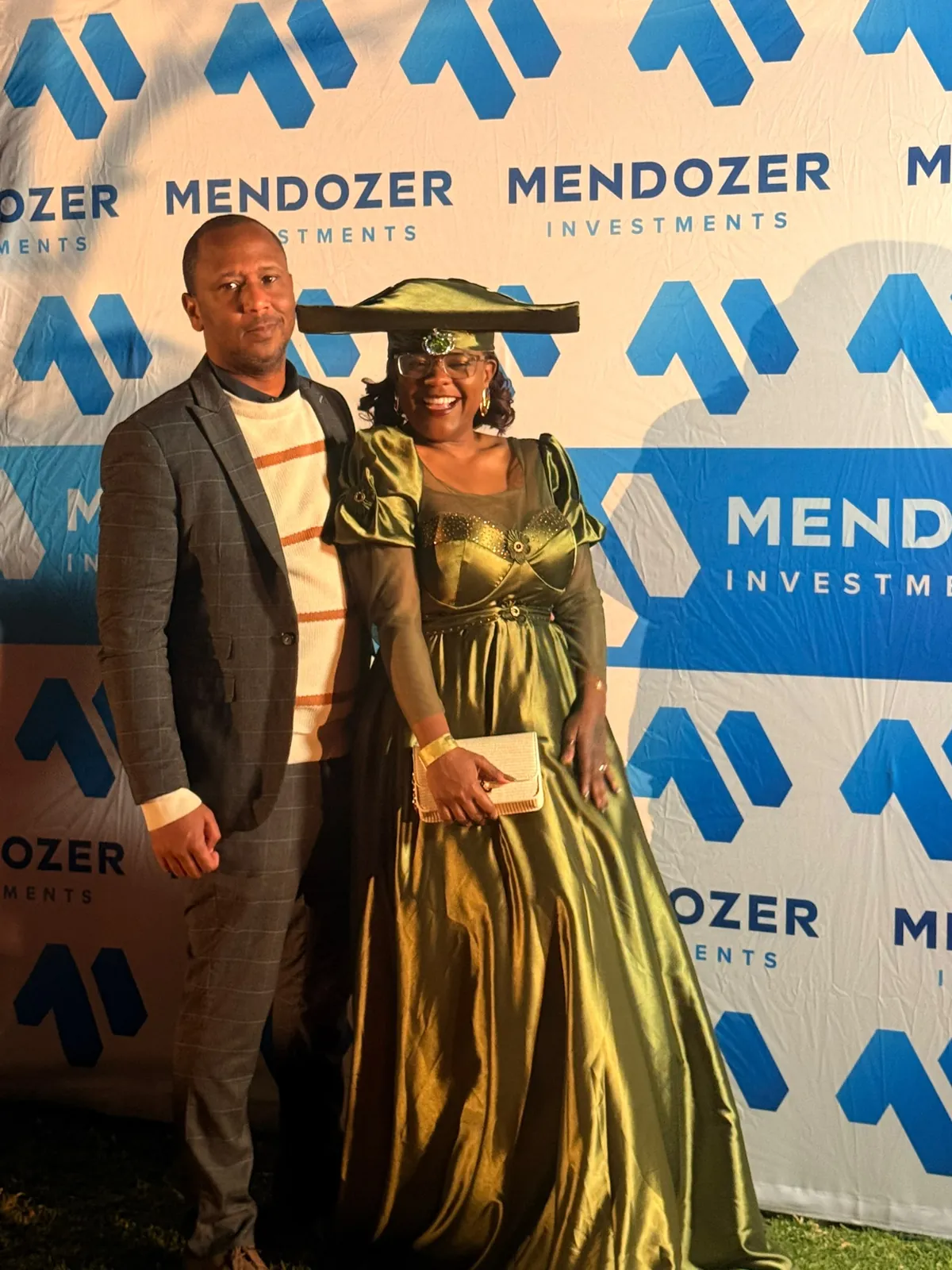 Guests posing together at a Mendozer-branded event backdrop