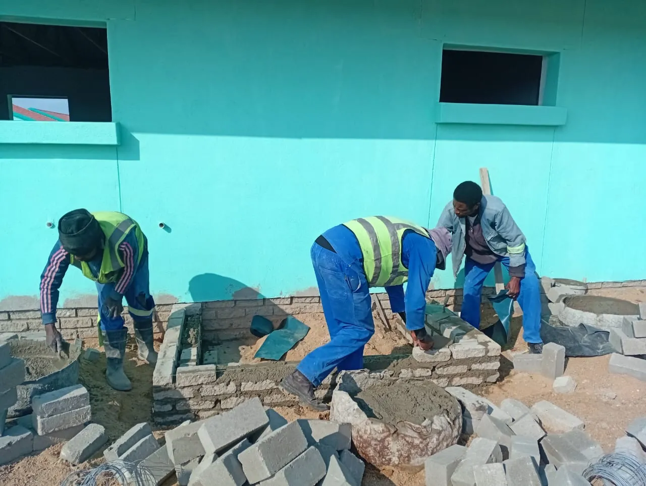 Bricklaying team building a wall on an active site
