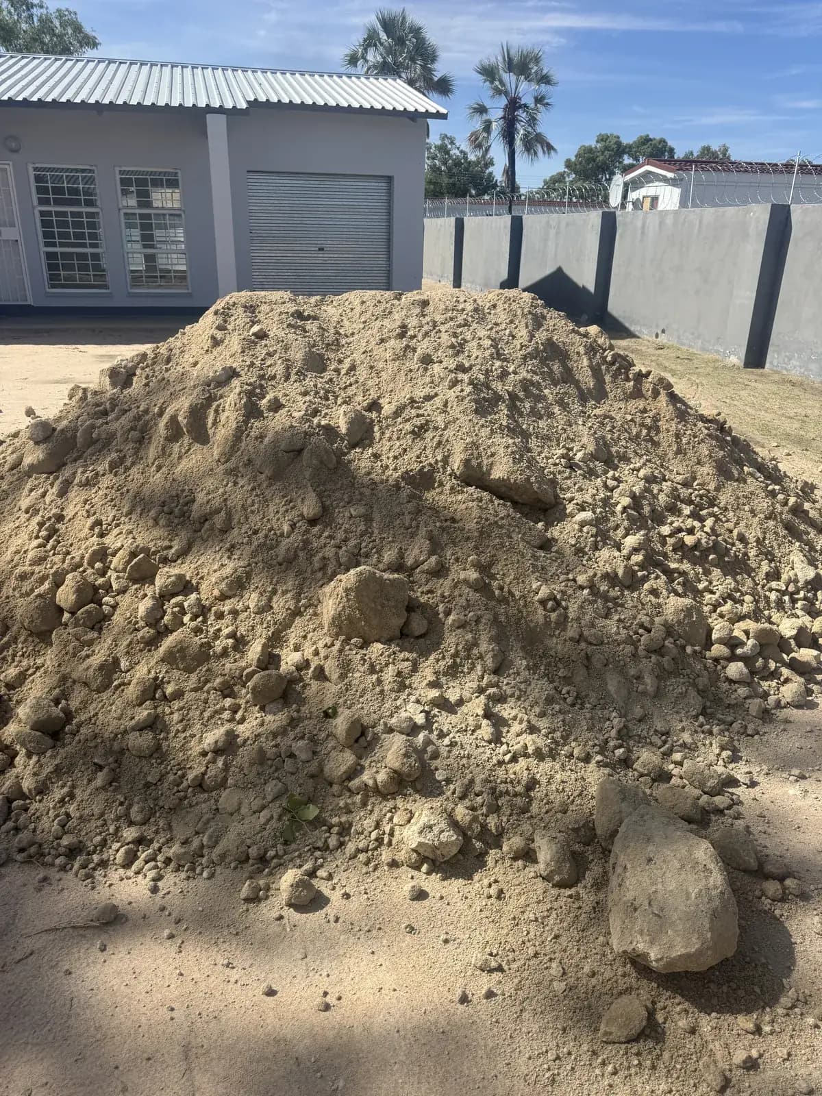 Building exterior beside a sandy work site