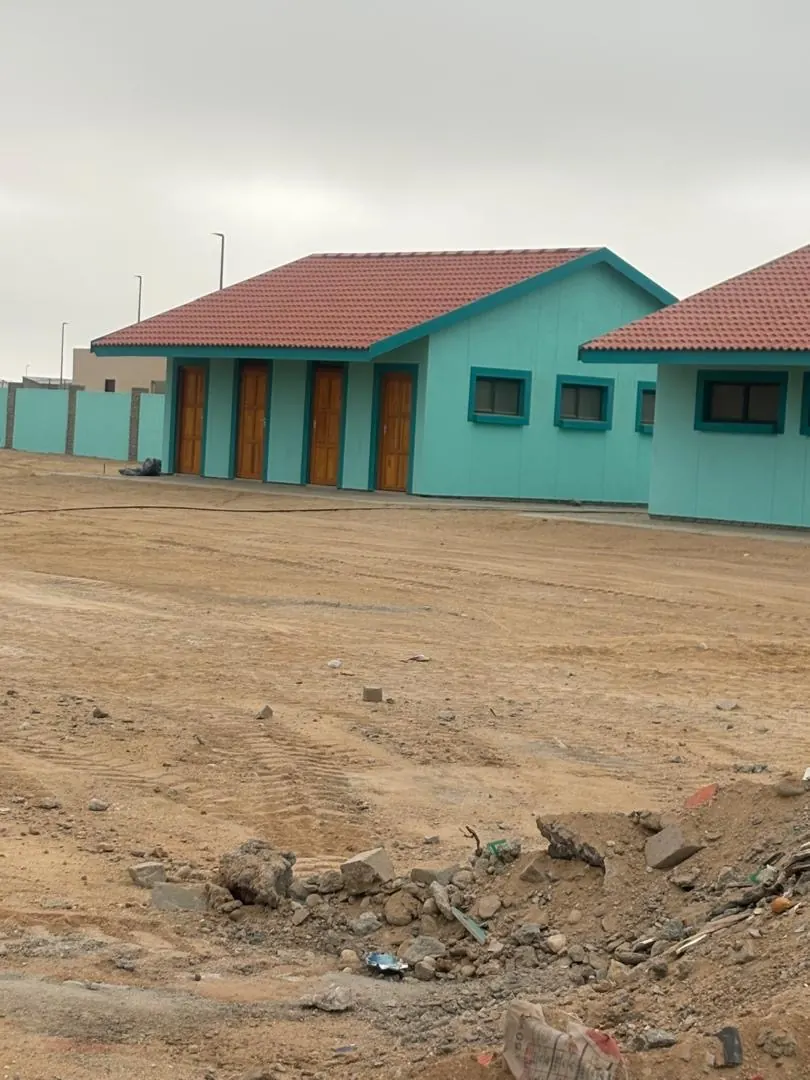 Perimeter walling and stockpiles beside a completed classroom block in Henties Bay