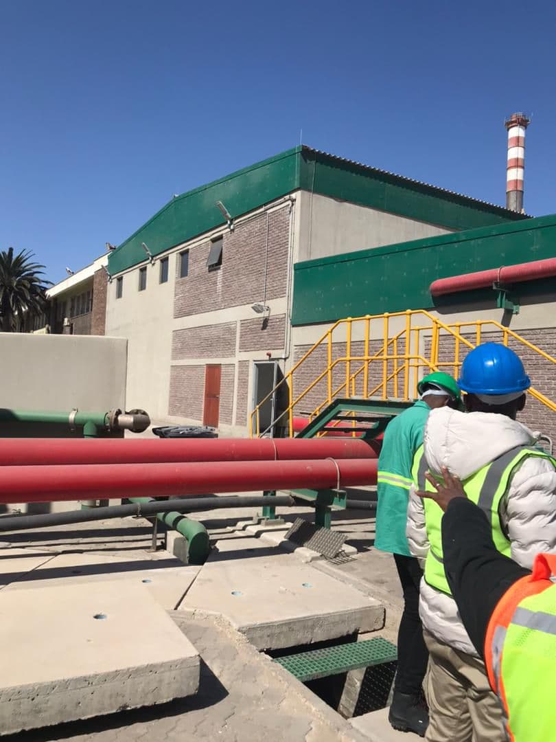 Industrial piping beside a facility building