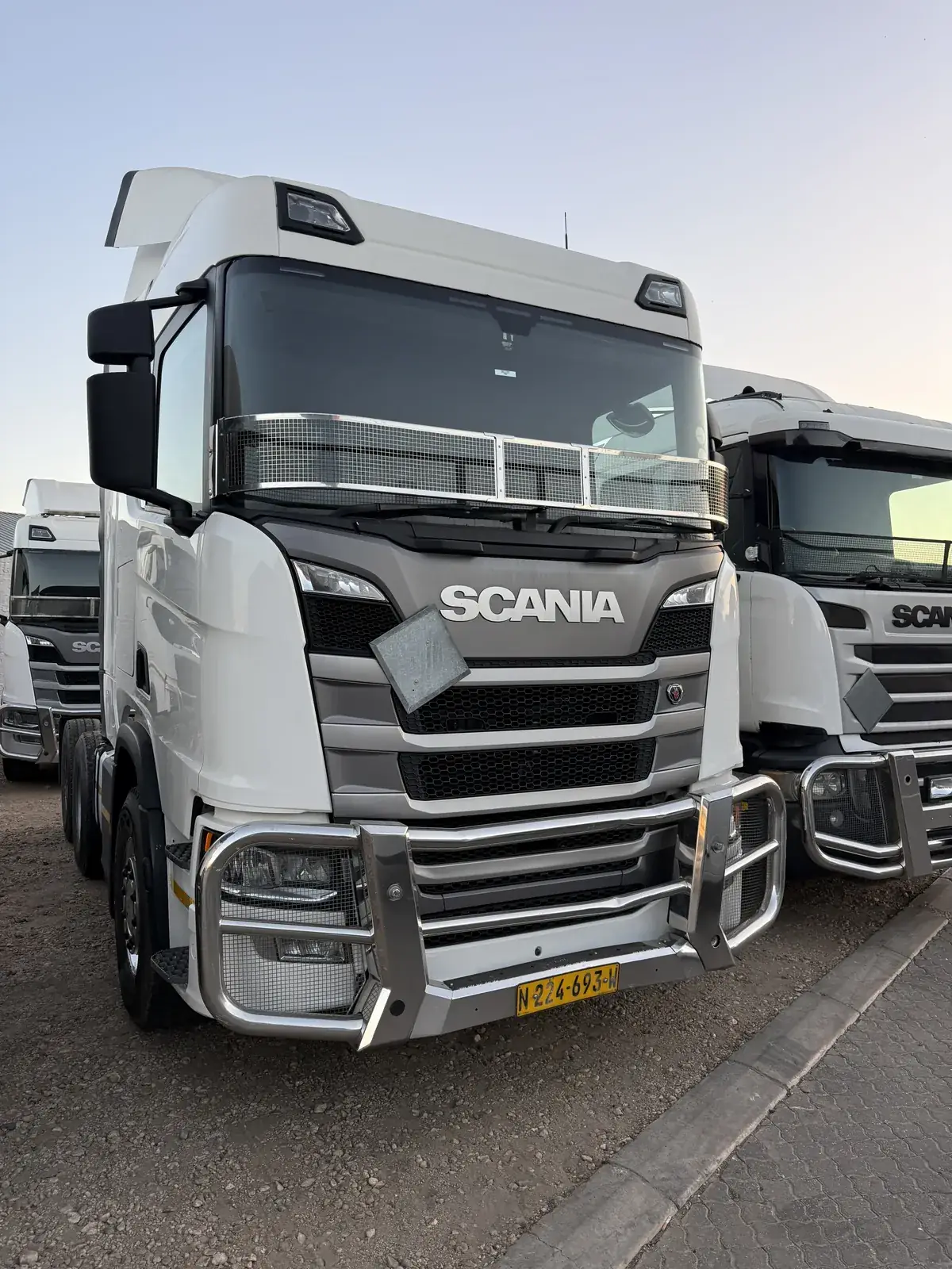 Heavy trucks parked at a depot in a line