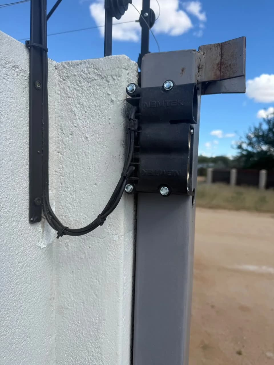 Close view of a Nemtek bracket carrying electric fence wiring