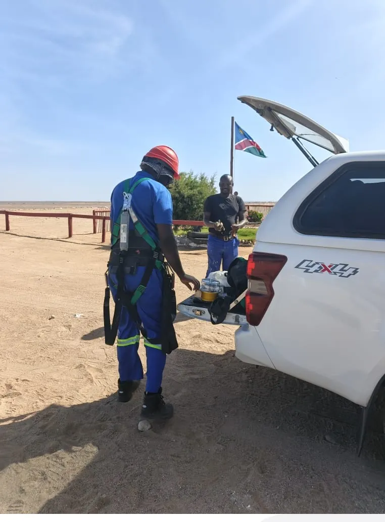 Field crew preparing equipment beside a vehicle