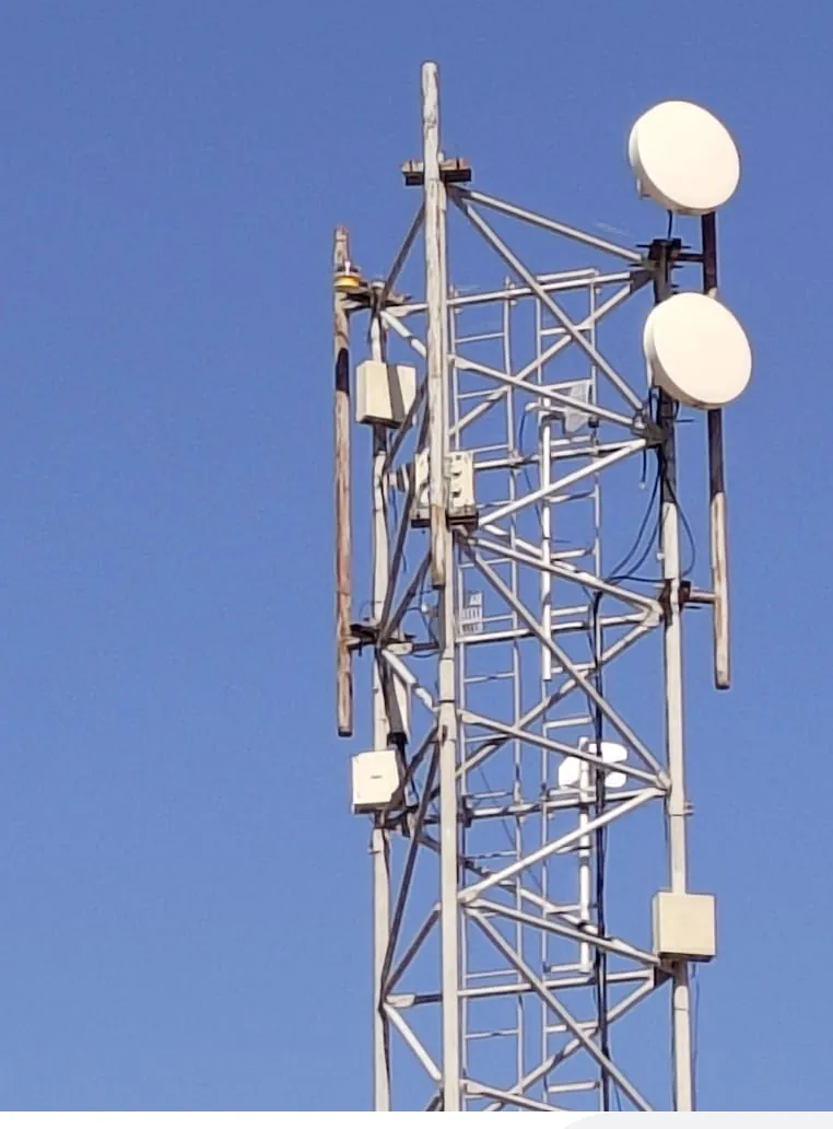 Communications tower equipment against a clear sky