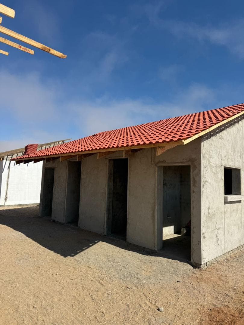 A building under construction beside an open site