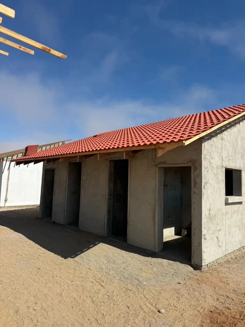 A building under construction beside an open site