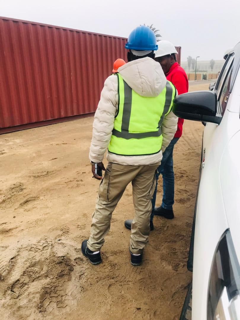 A team beside a container at a work site