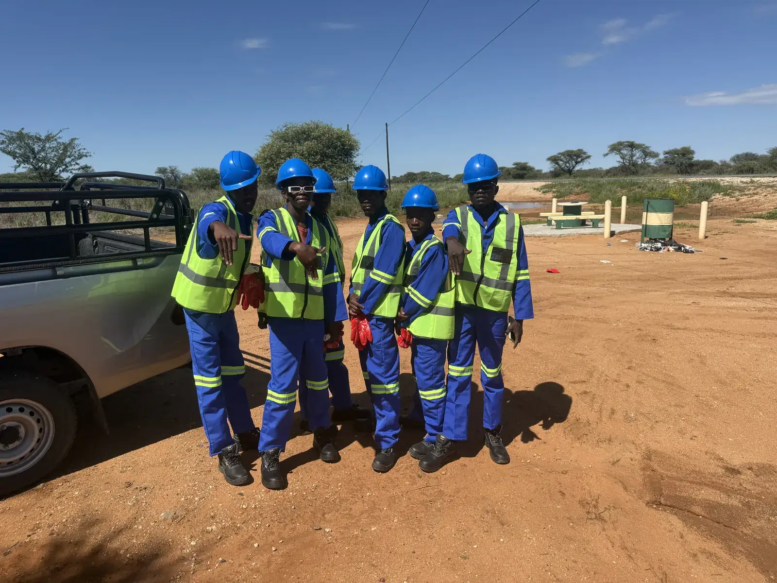 Mendozer crew giving a thumbs up beside a site vehicle