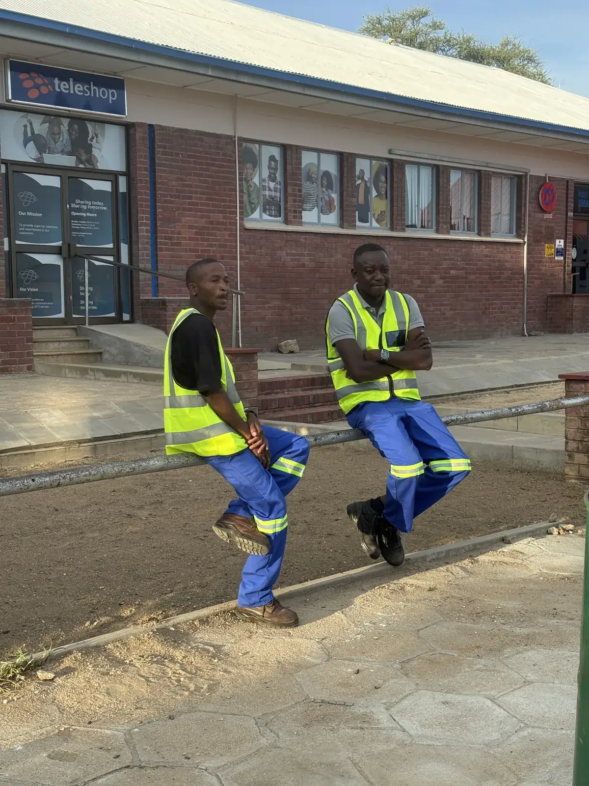 Mendozer crew members in branded wear beside a work building